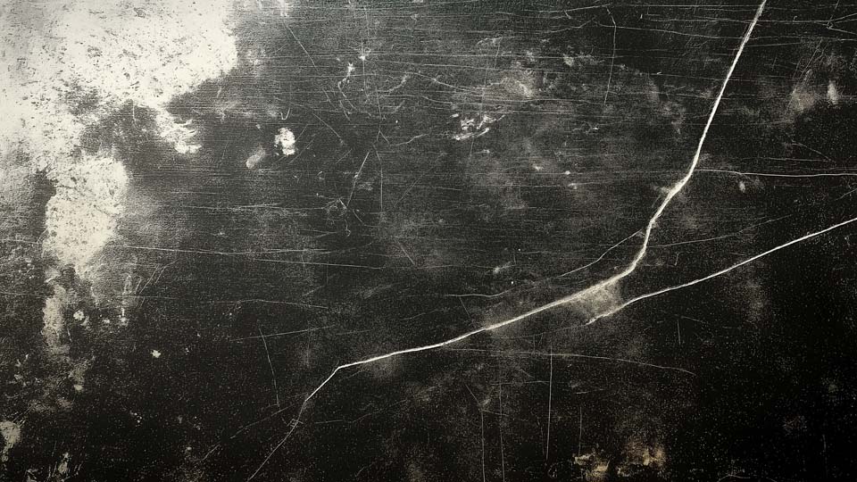 Dirty, scratched, and worn black metal surface