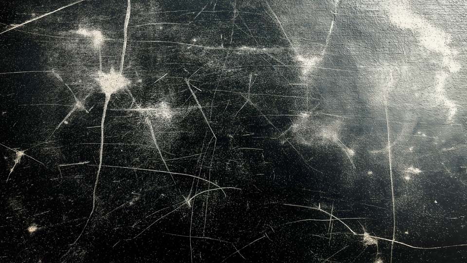 Dirty, scratched, and worn black metal surface