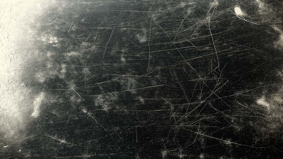 Dirty, scratched, and worn black metal surface