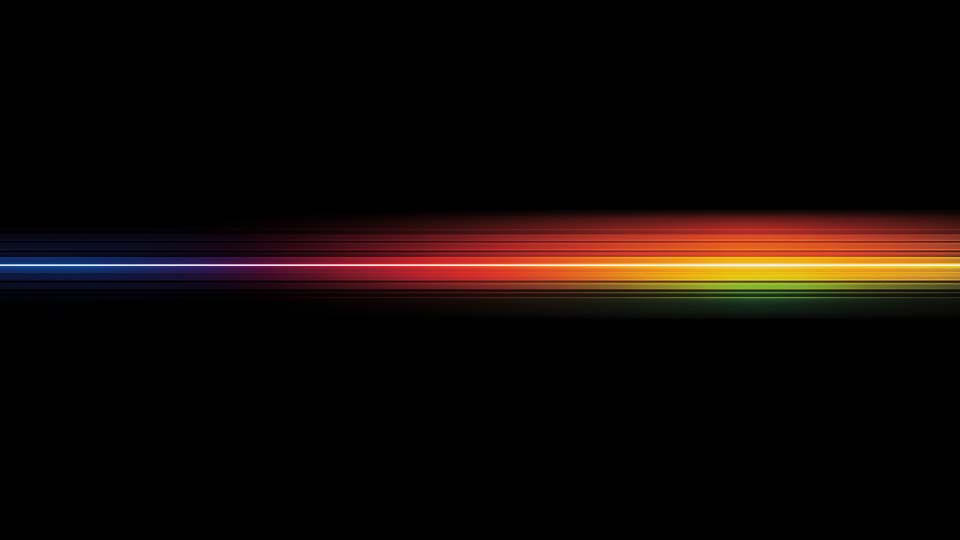 Horizontal rainbow-colored light streak on a black background