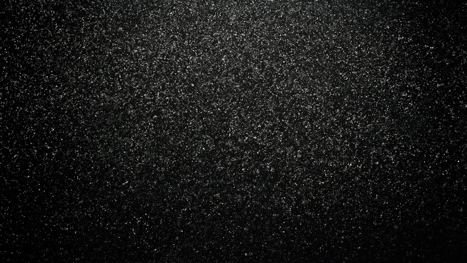 Black texture with scattered grainy particles