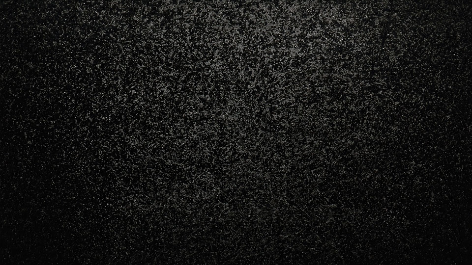 Black texture with scattered grainy particles