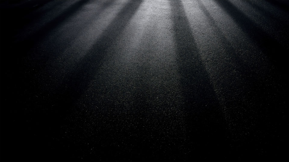 Spotlight on textured asphalt with dramatic highlights