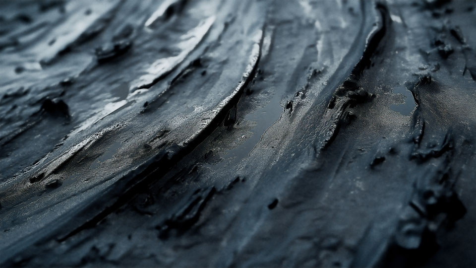 Tire tracks in mud on a wet, textured surface