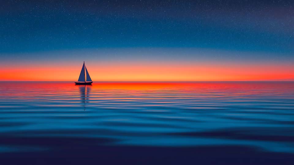 Sailing boat on a calm sea at sunset