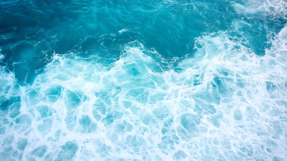 Blue sea water with white foam