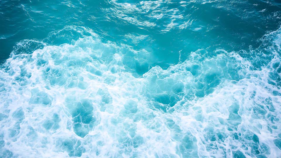 Blue sea water with white foam