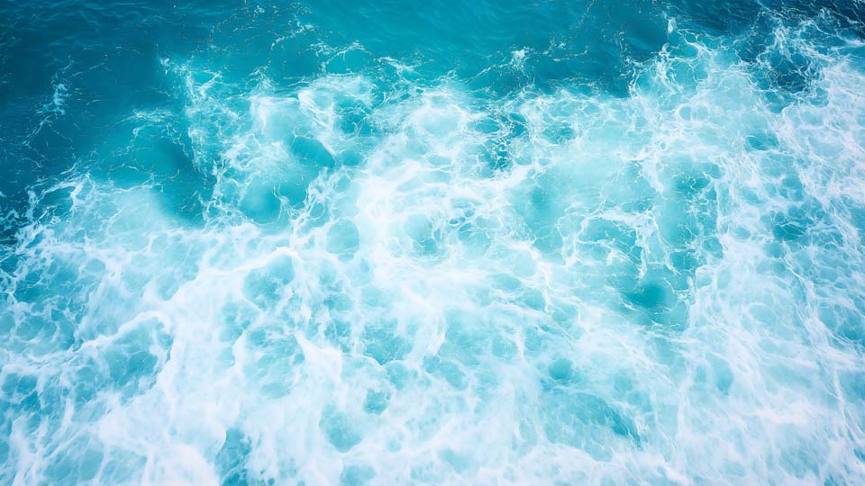 Blue sea water with white foam