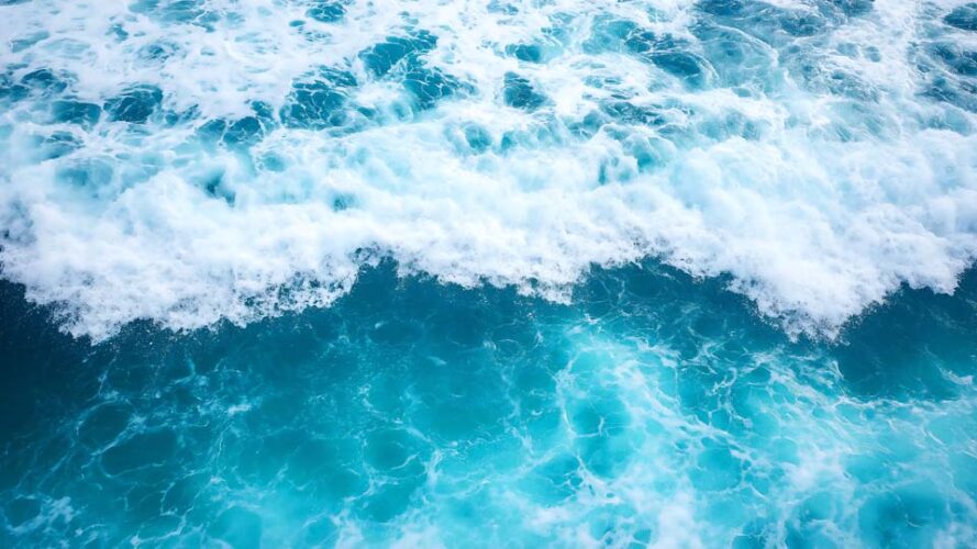 Blue sea water with white foam