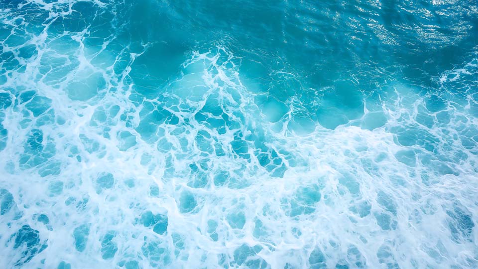 Blue sea water with white foam