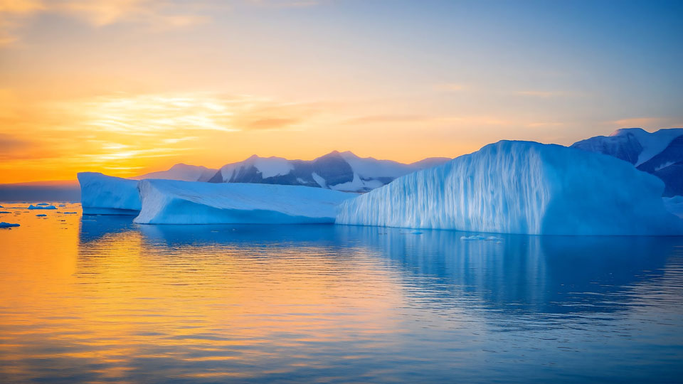 Iceberg floating in the water at sunset