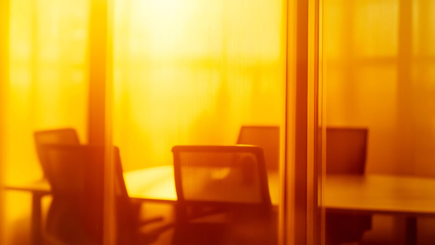 Empty boardroom with chairs and a table bathed in sunlight