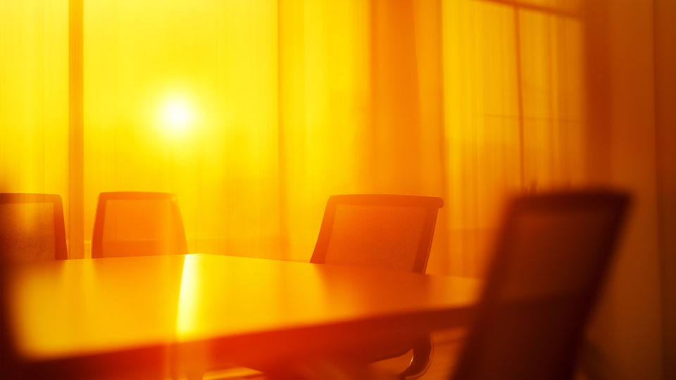 Empty meeting room with chairs and a table bathed in sunlight