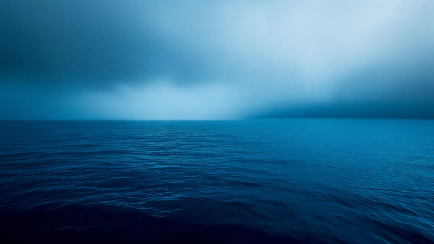 Calm blue ocean horizon at night