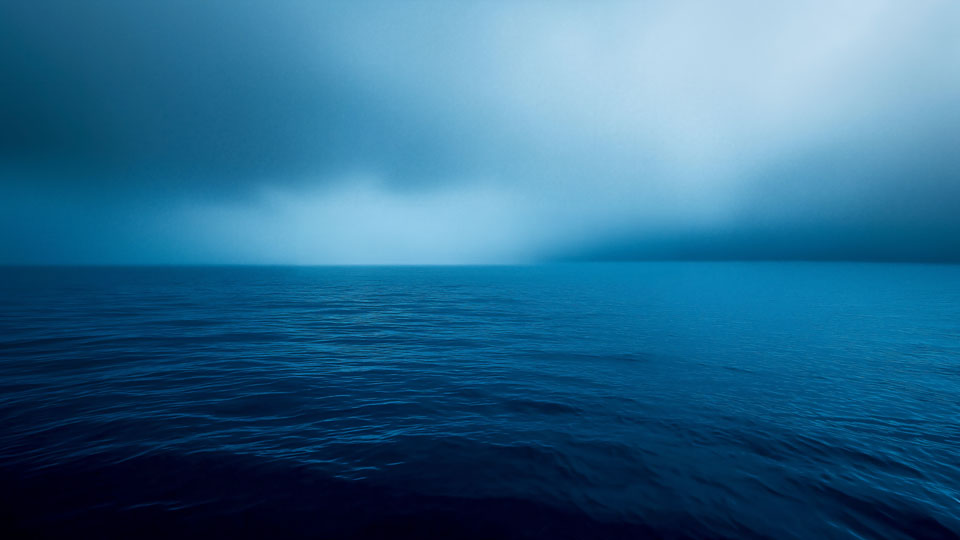 Calm blue ocean horizon at night