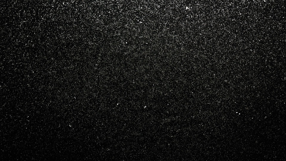 Black texture with scattered grainy particles