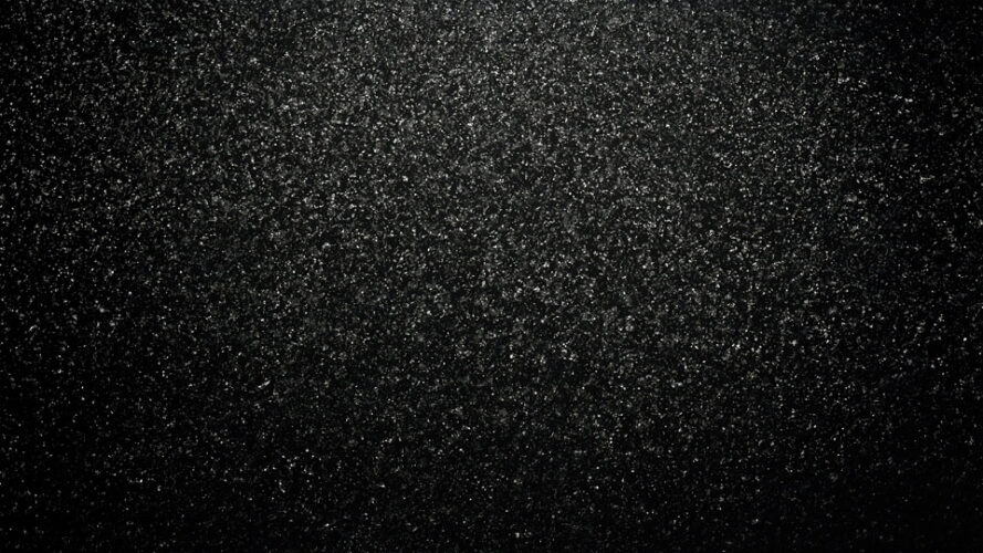 Black texture with scattered grainy particles