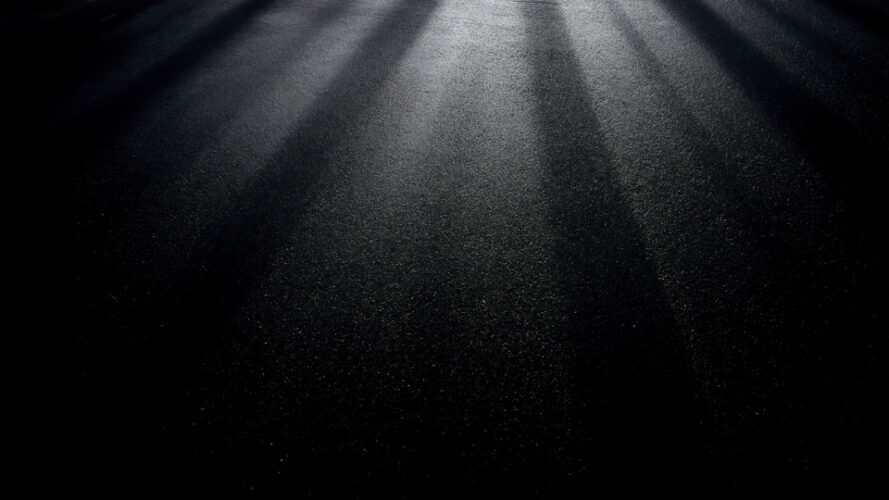 Spotlight on textured asphalt with dramatic highlights