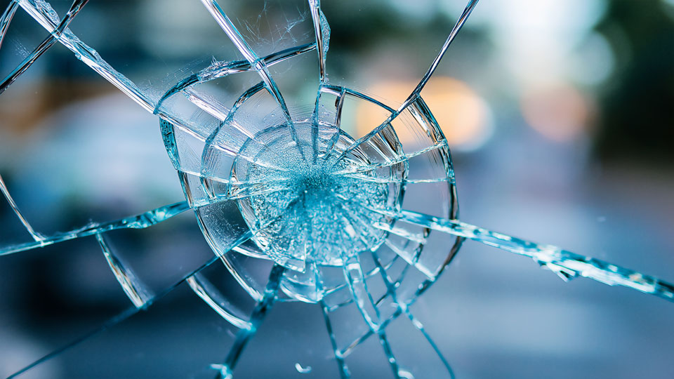 Broken glass with blue urban background