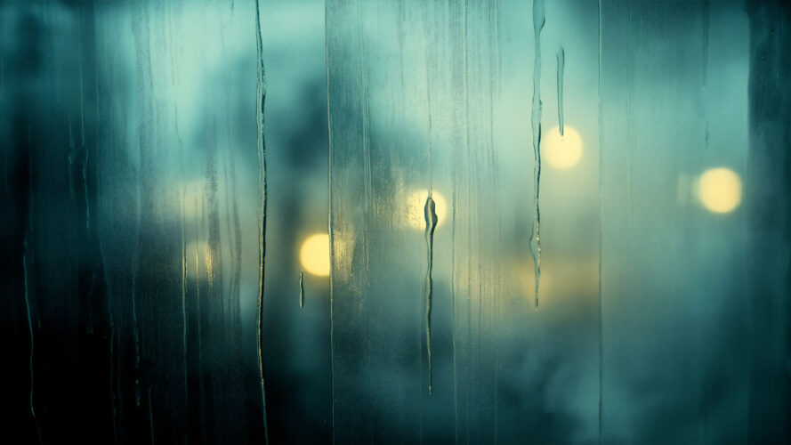 Rainy window with blurred city lights