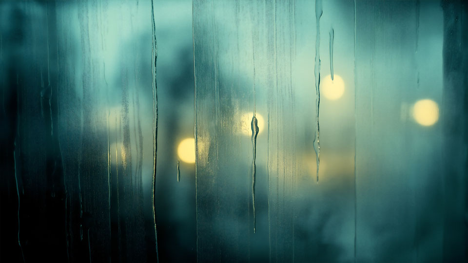 Rainy window with blurred city lights